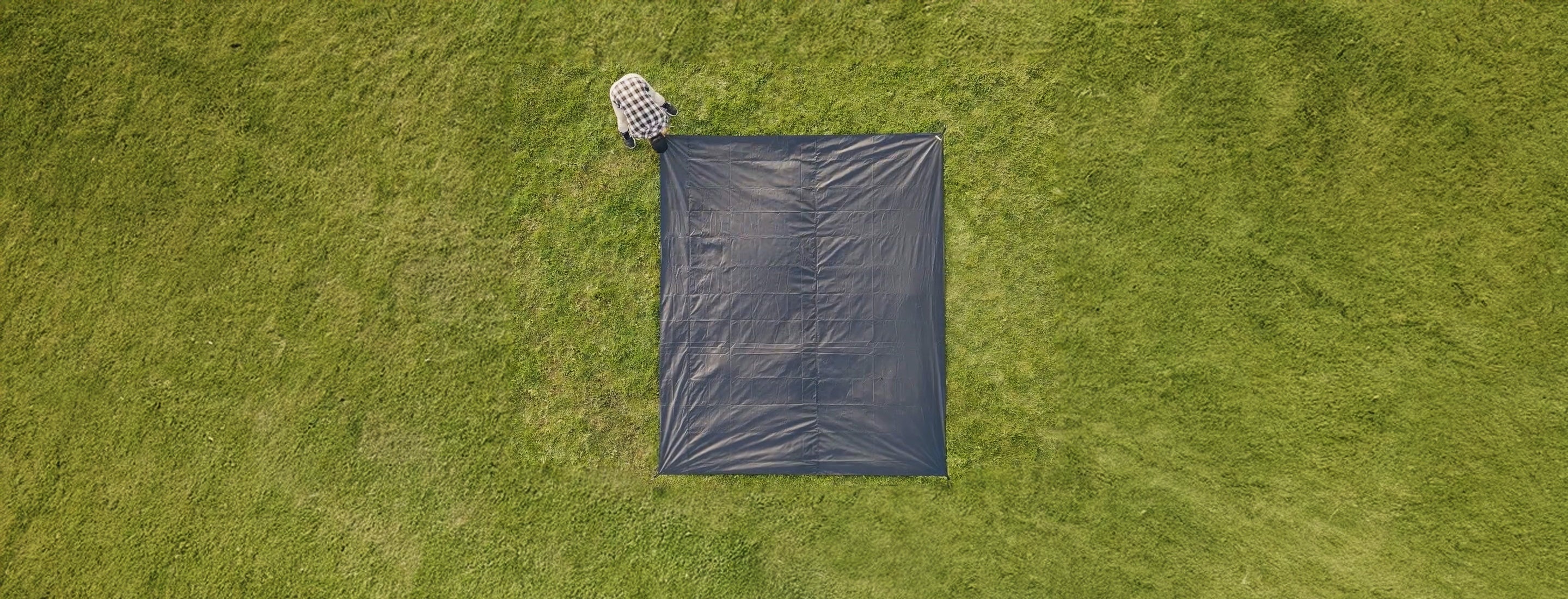 Black tarp on grass from an aerial view